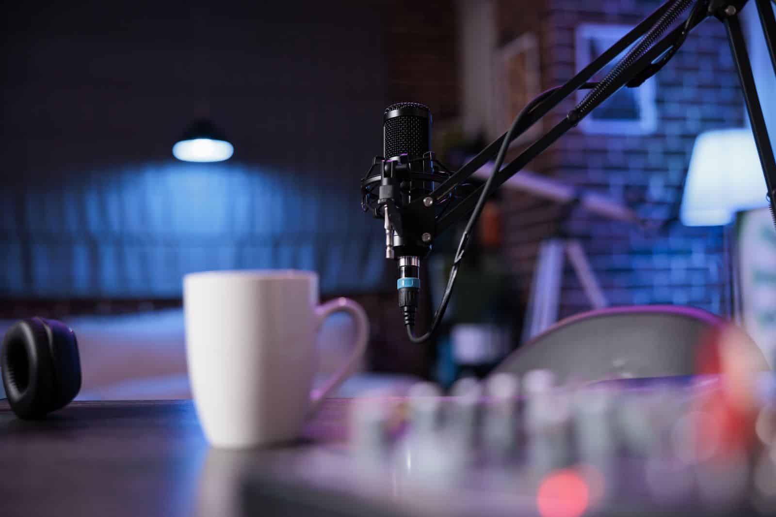 Mavi ışıklı bir podcast stüdyosunda kurulu profesyonel mikrofon